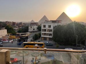 a view of the pyramids in a city with a bus at Sphinx and Pyramids INN in Cairo