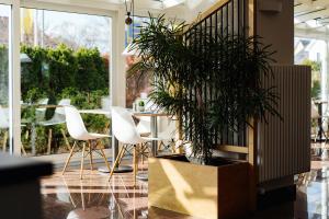 comedor con mesa, sillas y maceta en Hotel Stadt Gehrden, en Gehrden