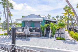 um restaurante com mesa, cadeiras e palmeiras em Awai's Floating Villa - Houseboat in Luxury Village em Key West