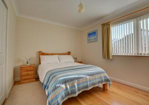 a bedroom with a bed and a window at Oak Tree Cottage in Old Buckenham