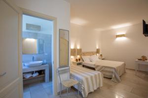 una camera con letto, lavandino e specchio di Il Torrino B&B a Sannicola