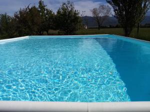 una gran piscina azul con agua azul en Ca' del Sale - Agriturismo con piscina e campo da tennis vicinanze Cinque Terre, en Ameglia
