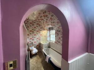 a bathroom with a tub and a pink wall at Clint Lodge in Melrose +74 photos