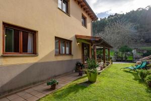 a house with a yard with green grass and plants at Casa rural playa nves002r in Naves