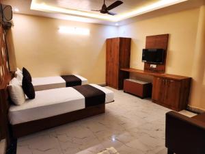een hotelkamer met 2 bedden en een televisie bij Hotel Grand Patliputra in Siwān