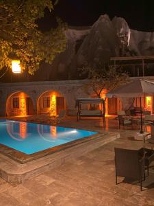 una piscina por la noche con una casa de iguanas en Seven Rock Cave Hotel en Goreme