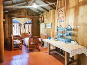 a room with wooden walls and a table and chairs at Chadatarn HomeStay in Ban Pok Nai