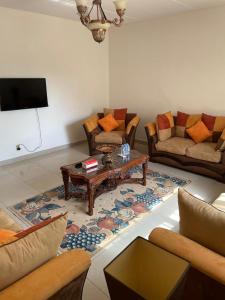 ein Wohnzimmer mit Sofas und einem Couchtisch in der Unterkunft فيلاً بالقرب من البحر in Al Fanātīr