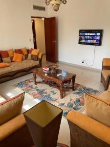 ein Wohnzimmer mit Sofas und einem Couchtisch in der Unterkunft فيلاً بالقرب من البحر in Al Fanātīr
