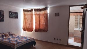 a bedroom with a bed and a window with curtains at Aguascalientes feria nacional de San Marcos in Aguascalientes