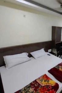 a white bed with two pillows on top of it at Swastik Guest House Inn Varanasi in Varanasi
