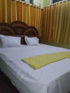 a bedroom with a bed with white sheets and pillows at Swastik Guest House Inn Varanasi in Varanasi
