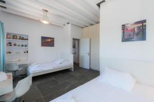 Habitación blanca con 2 camas y escritorio. en blue paradise villa, en Sifnos