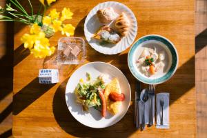 Hotel Kailani في Oshima: طاولة مع أطباق من الطعام ووعاء من الشوربة