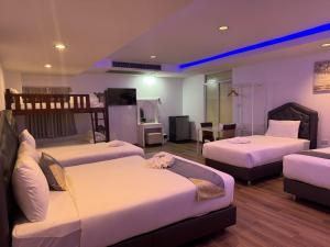 a hotel room with two beds and a living room at Neo Hatyai Hotel in Hat Yai