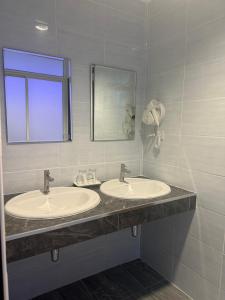 a bathroom with two sinks and a mirror at Neo Hatyai Hotel in Hat Yai