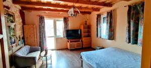 a bedroom with a bed and a tv and a couch at bellavitavilla2020 in Siófok