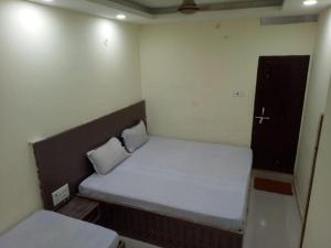 a small bed in a small room with two pillows at Swastik Guest House Inn Varanasi in Varanasi