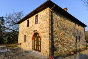 a large brick building with a door and a patio at Palagina la cascina in Figline Valdarno