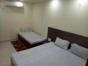 a small room with two beds and a bench at Swastik Guest House Inn Varanasi in Varanasi