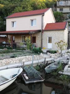 una casa con barcos en el agua delante de ella en Apartman Mustapić, en Pižnovac 6 fotos más
