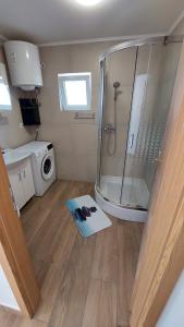 y baño con ducha y lavadora. en Apartman Mustapić, en Pižnovac