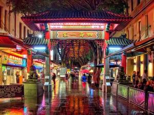 a city street at night with people walking in the rain at Private Triple Room in Sydney City Near TrainBus UTS DarHar&ICC&ChinaTown - ROOM ONLY in Sydney