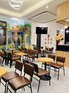 a restaurant with tables and chairs and a mural at HATY MOTEL & COFFEE in Pleiku
