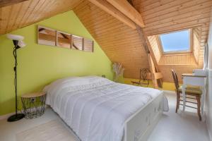 a bedroom with a large white bed in a attic at Maison pour 7 avec piscine à Préfailles in Préfailles +24 photos
