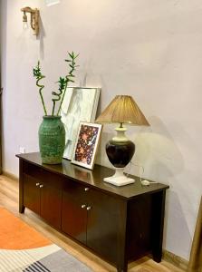 einen Tisch mit einer Lampe und einer Vase darauf in der Unterkunft The General's House in Hanoi