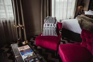 a bedroom with a bed and a chair and a table at Hotel Gotham in Manchester