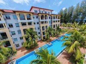 an aerial view of a hotel with a pool and palm trees at Desaru Black Beach Sky Mirror Resort in Desaru