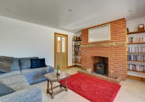 a living room with a couch and a brick fireplace at Dentford Heights in Beetley