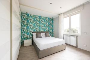 - une chambre avec un lit et un mur bleu et blanc dans l'établissement Orto Botanico Family Flat by Wonderful Italy, à Naples