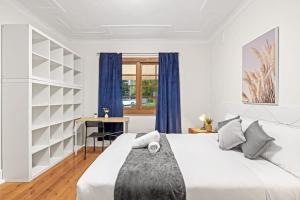 Habitación blanca con cama y escritorio en Private Room in Gordon near Train & Bus Sleeps 2 en Pymble