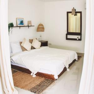 1 dormitorio con 1 cama con espejo en Twin Palms Surfhouse en Thulusdhoo