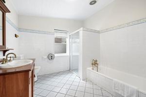 baño blanco con ducha y lavamanos en Quadruple Room in Gordon near Train & Bus Sleeps 4, en Pymble