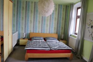 een slaapkamer met een bed met gestreepte lakens erop bij XXL Ferienliebe in Habrachćicy