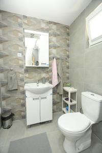 a bathroom with a white toilet and a sink at Apartman Plaža 2 in Kladovo