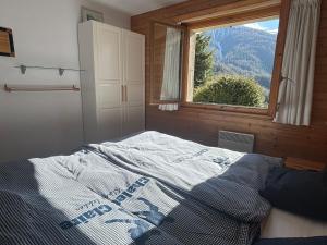 a bedroom with a bed and a window with a view at Chalet Claire in Bürchen