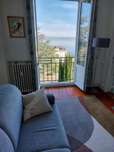 a living room with a couch and a large window at Le Mirabeau Vue Lac in Évian-les-Bains