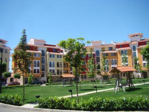 uma fila de edifícios de apartamentos com árvores num parque em Relaks w Marina Cape 88 em Aheloy