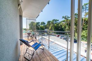 a balcony with chairs and a view of a street at WYDMA Resort Medi & SPA - Normobaria in Mrzeżyno