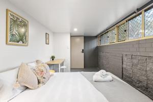 Un dormitorio con una gran cama blanca y una mesa en Pymble private room Sleeps 2 en Pymble
