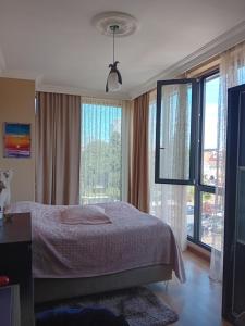 1 dormitorio con cama y ventana grande en Apartment Chavchavadze 21, en Batumi