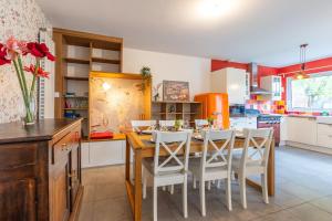 - une cuisine avec une table en bois et des chaises blanches dans l'établissement La Maison Coquelicot - Havre de paix à Rennes, à Rennes