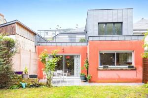 an orange and white house with a courtyard at La Maison Coquelicot - Havre de paix à Rennes in Rennes