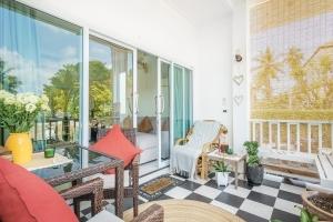 um pátio com uma mesa de vidro e cadeiras num alpendre em Sunset beach apartments 9 La Bella Villa em Ko Phangan