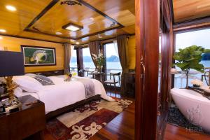 - une chambre sur un bateau avec un lit et une baignoire dans l'établissement Hera Cruises Group on Ha Long Bay, à Hạ Long
