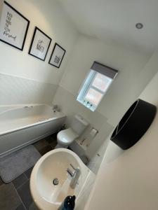 Seaham Sea View 2 bedroom apartment في سيهام: حمام مع مرحاض ومغسلة وحوض استحمام